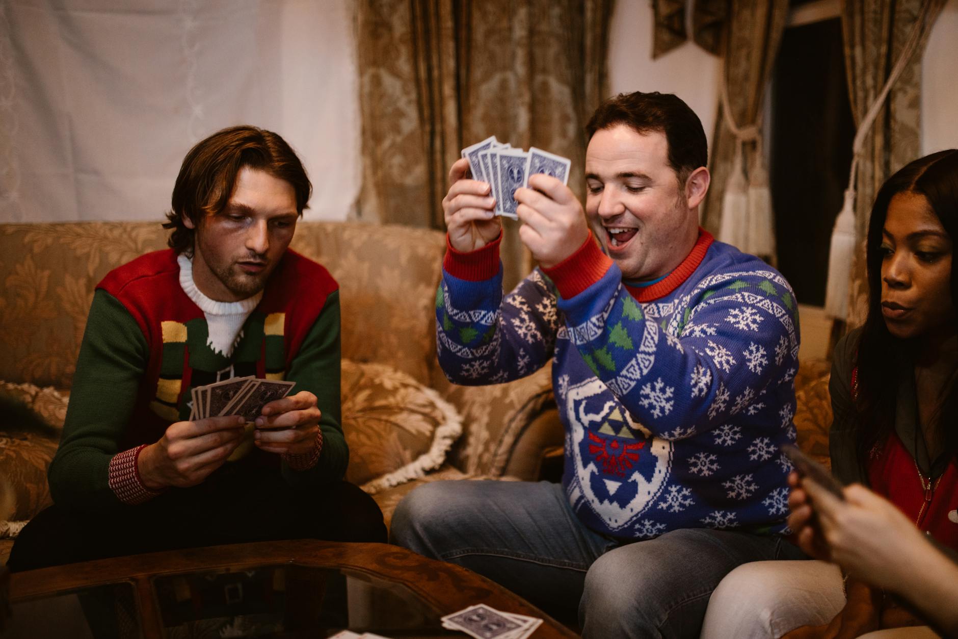 people playing cards at ugly christmas sweater party